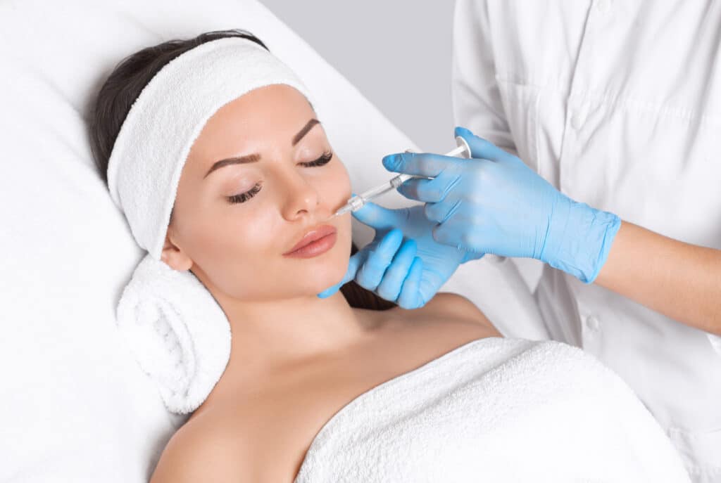 Relaxed woman getting dermal filler injections in New York, NY